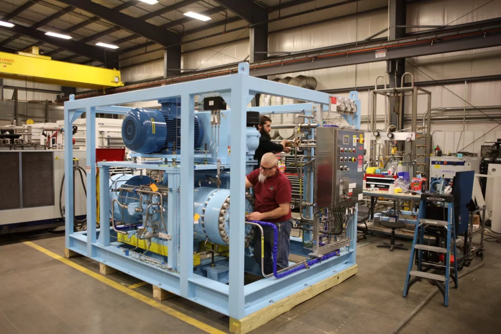 PDC Machines Technicians Servicing Diaphragm Gas Compressor at Manufacturing Plant