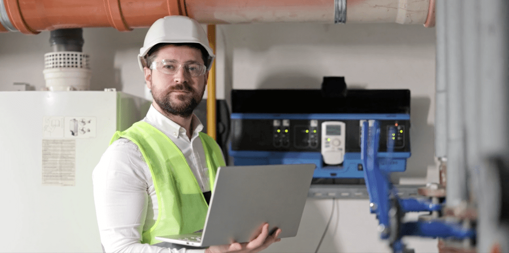 Industrial technician using a laptop on-site, illustrating Industrility’s asset-centric customer portals for connected equipment, service data, and digital support