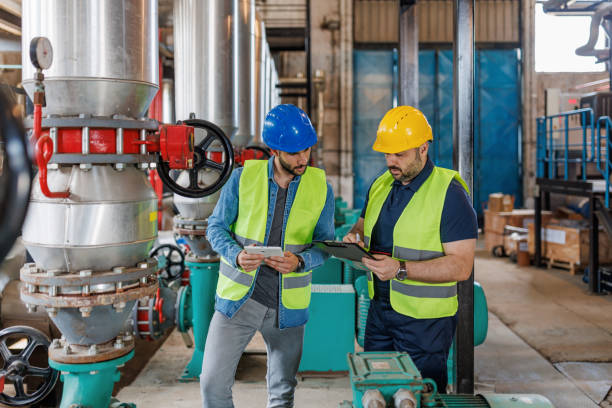 OEM engineers inspecting machinery in factory for service lifecycle management